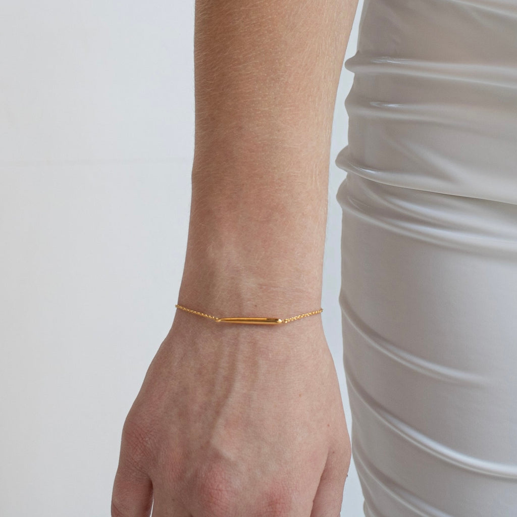 Gold Sofia bracelet being modeled on a wrist, showcasing its elegant design, polished finish, and adjustable hoops for a perfect fit.