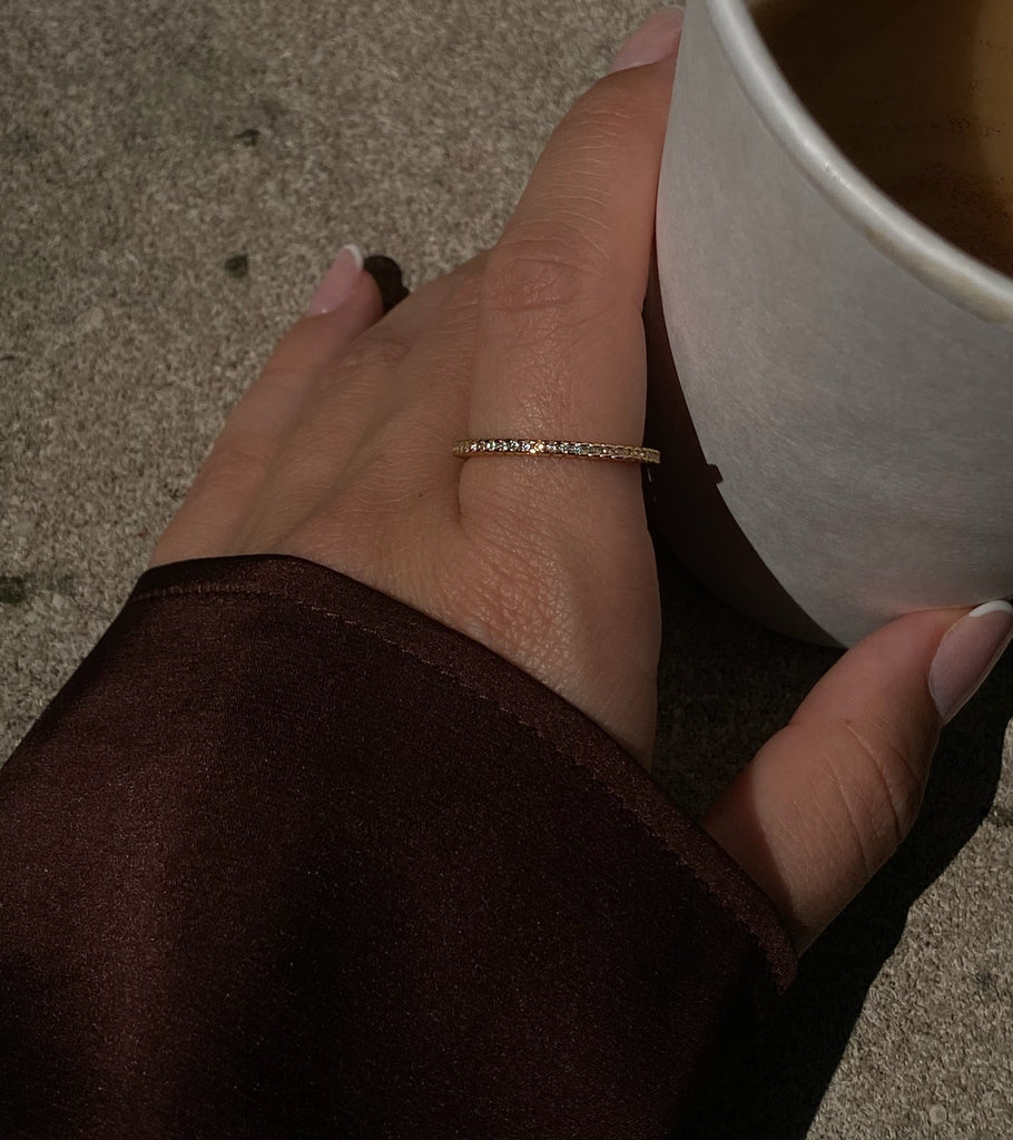 Stunning gold thin ring with brilliant diamonds encircling the band, a luxurious piece perfect for stacking or special occasions.